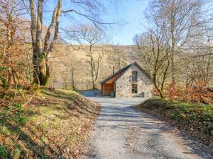 a small stone building on a dirt road at Boat House in Invergarry