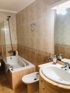 a bathroom with a bath tub and a sink and a bath tub at Apartamento Único in Vigo