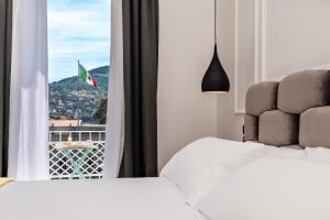 a bedroom with two beds and a window with a flag at La Spezia by The First - Luxury Rooms & Suites in La Spezia