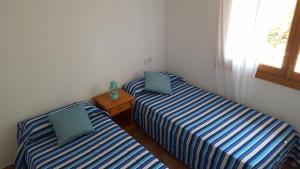 two twin beds in a room with a window at Can Tauet de ses Roques in Playa Migjorn