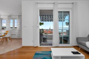 a white living room with a view of the city at Apartman Jug in Makarska