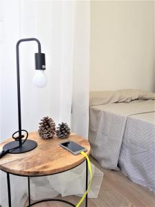 a table with a lamp and a laptop on it next to a bed at Immaculada Apartament Gandia in Gandía