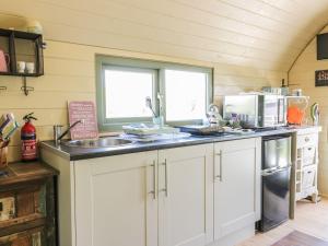 
a kitchen with a stove top oven and a sink at The Lamb Shack in Bodmin
