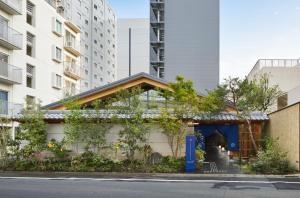 a building with a blue door in a city at ONSEN RYOKAN YUEN SHINJUKU in Tokyo +52 photos