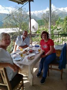 een groep mensen die aan een tafel zitten bij Saro B&B and Safari Tours in Tatʼev