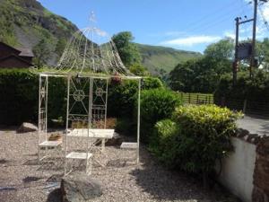 a white gazebo with two chairs in a garden at The New Inn in Oswestry