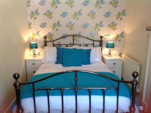 1 dormitorio con 1 cama con 2 mesitas de noche y 2 lámparas en The New Inn, en Oswestry