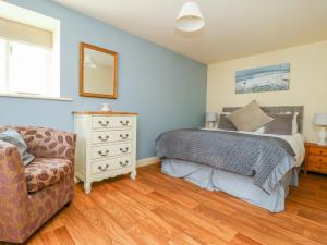 a bedroom with a bed and a chair at The Cottage in Thirsk