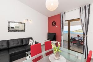 a living room with a black couch and red chairs at Apartment Dora in Ražanj