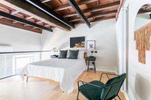 - une chambre avec un lit blanc et une chaise verte dans l'établissement Sonder Trastevere, à Rome