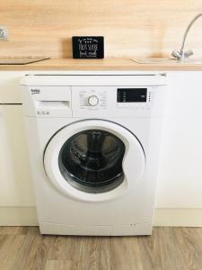 a white washing machine in a kitchen with a counter at Appartement cosy & reposant in Beauvais
