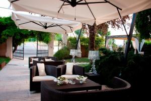 a patio with chairs and tables under an umbrella at Il Cecchini in Pasiano di Pordenone