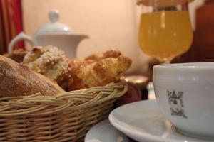 エクス・アン・プロヴァンスにあるオテル デ ゾーギュスタンのコーヒーとテーブルの上に食べ物のバスケット