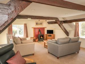 un soggiorno con divani e camino di Upper Barn Cottage a Minehead
