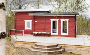 a red house with two dogs sitting on a deck at Marsfjäll Mountain Lodge Hotell i Saxnäs in Saxnäs