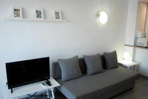 a living room with a couch and a flat screen tv at Minerva701 in Benalmádena
