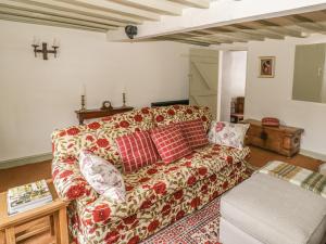 a living room with a couch and a table at Fountain View Cottage in Upper Heyford