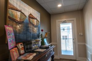 a room with a table with books and a painting on the wall at The Admiral Hotel/Motel in Ocean City