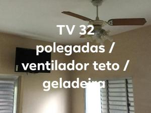 um ventilador de tecto num quarto com janela em Pousada Sintramog em Bertioga