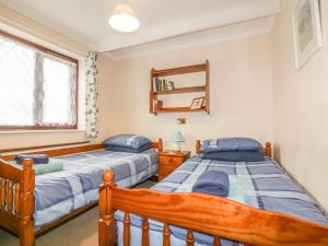a bedroom with two beds and a window at Chiffchaff in Padstow