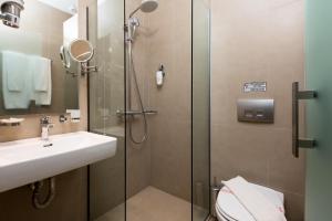 a bathroom with a shower and a sink and a toilet at Princess Golden Beach Hotel in Chrysi Ammoudia