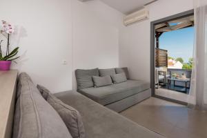 a living room with a couch and a large window at Princess Golden Beach Hotel in Chrysi Ammoudia
