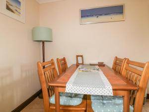 a dining room table with four chairs and a lamp at Chiffchaff in Padstow +8 photos