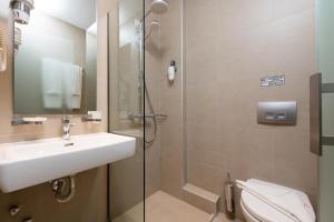 a bathroom with a sink and a shower and a toilet at Princess Golden Beach Hotel in Chrysi Ammoudia