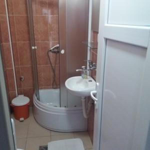 een badkamer met een douche, een wastafel en een toilet bij Apartments Šofranac in Podgorica