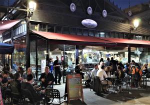 a group of people sitting at tables outside a restaurant at Immaculada Apartament Gandia in Gandía