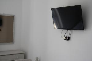 telewizor z płaskim ekranem wiszący na ścianie w obiekcie Kalypso Apartments w mieście Lipsi