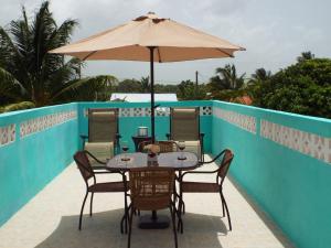 einen Tisch und Stühle mit Sonnenschirm auf dem Balkon in der Unterkunft LAKE VIEW CONDO in Belize City