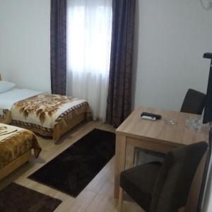 Cette chambre comprend un lit, un bureau et une table. dans l'établissement Apartments Šofranac, à Podgorica