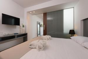 a bedroom with two towels sitting on a bed at Princess Golden Beach Hotel in Chrysi Ammoudia