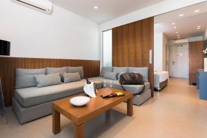 a living room with a couch and a table at Princess Golden Beach Hotel in Chrysi Ammoudia