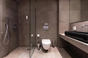 a bathroom with a toilet and a glass shower at Princess Golden Beach Hotel in Chrysi Ammoudia