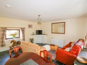 a living room with two couches and a table at Camellia Cottage in Bodmin