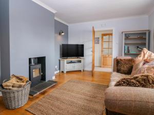 a living room with a couch and a fire place at The Hollows in Portree