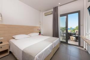 a bedroom with a large bed and a balcony at Princess Golden Beach Hotel in Chrysi Ammoudia