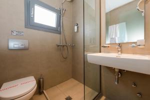 a bathroom with a shower and a toilet and a sink at Princess Golden Beach Hotel in Chrysi Ammoudia
