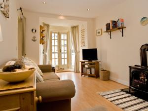 a living room with a couch and a fireplace at Bwthyn Llechen in Porthmadog