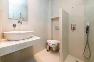 a white bathroom with a sink and a toilet at Princess Golden Beach Hotel in Chrysi Ammoudia
