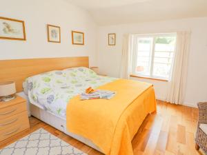 a bedroom with a bed with a yellow blanket at The Mill House in Saint Columb Major