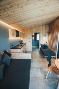 kuchnia i salon z drewnianymi sufitami i meblami w obiekcie Bacher'stay w mieście Bressanone