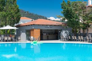 a swimming pool in front of a building at Princess Golden Beach Hotel in Chrysi Ammoudia