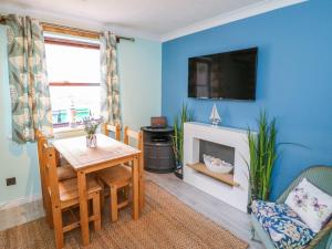 a living room with a table and a fireplace at Whitby Sands in Whitby