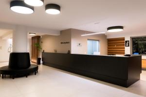 a waiting room with a reception desk and a black chair at Princess Golden Beach Hotel in Chrysi Ammoudia