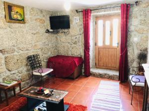 a living room with a table and chairs and a door at Casa da Quinta da Prelada Simão partie basse in Celorico de Basto