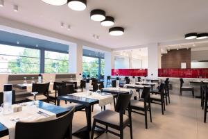 a dining room with tables and chairs and large windows at Princess Golden Beach Hotel in Chrysi Ammoudia