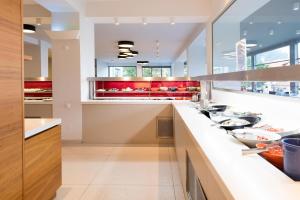 a large kitchen with a counter with many dishes at Princess Golden Beach Hotel in Chrysi Ammoudia